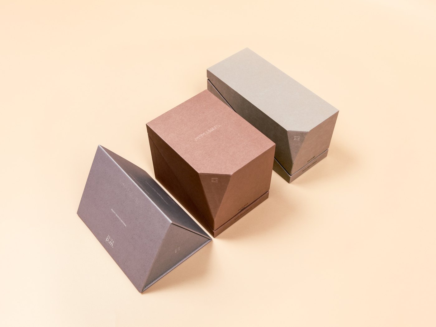 Angled prism boxes with chamfered lids and blind-embossed marks